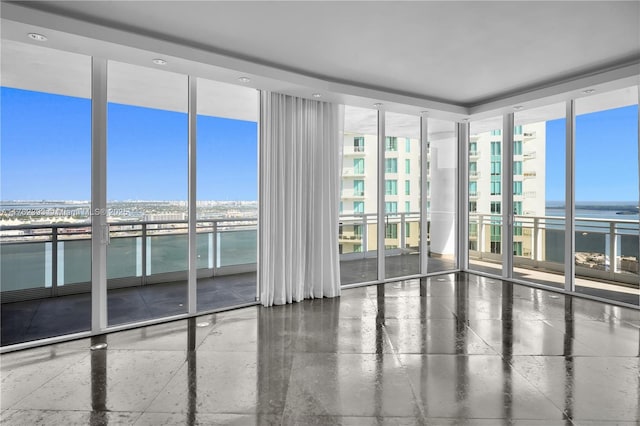 empty room featuring a water view and floor to ceiling windows