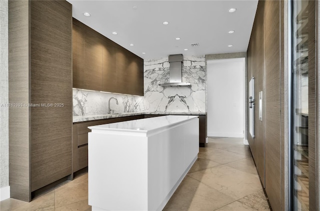 kitchen featuring a center island, modern cabinets, and wall chimney exhaust hood