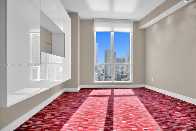 spare room with brick floor, baseboards, and a view of city