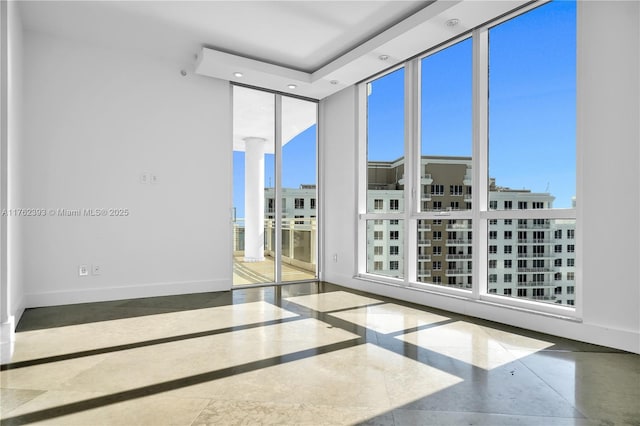 spare room with a wall of windows, baseboards, and recessed lighting