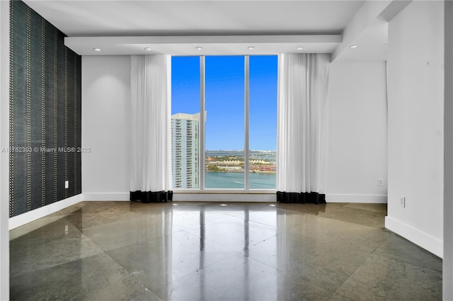 unfurnished room with a wall of windows, recessed lighting, and baseboards