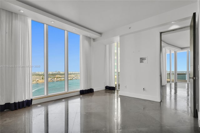 spare room with a wall of windows, recessed lighting, and baseboards