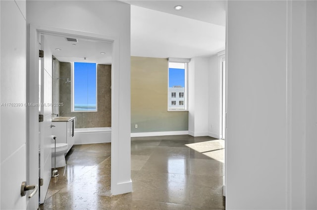 hall featuring visible vents and baseboards