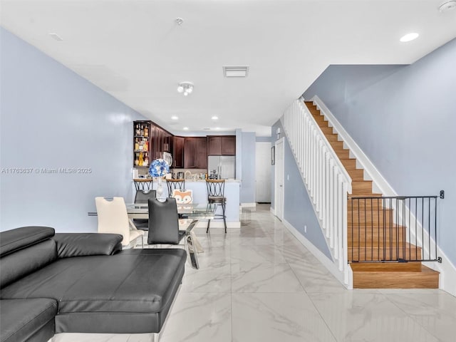 living area featuring visible vents, marble finish floor, recessed lighting, baseboards, and stairs