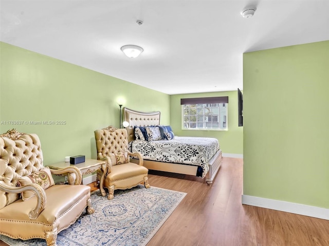 bedroom with baseboards and wood finished floors