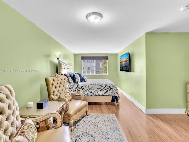 bedroom featuring baseboards and wood finished floors