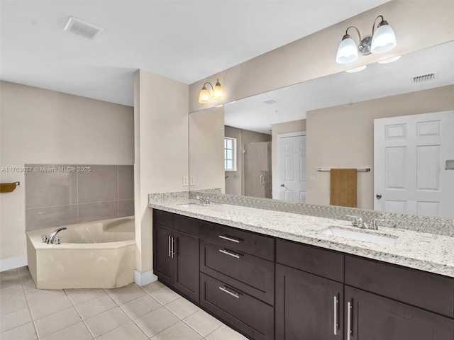 bathroom with tile patterned flooring, visible vents, a garden tub, and a sink