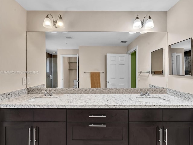 bathroom with a sink, visible vents, a stall shower, and double vanity