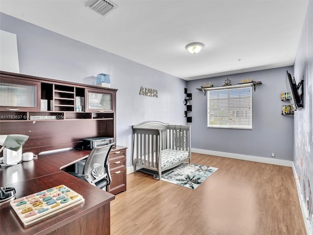 bedroom with visible vents, baseboards, and light wood finished floors