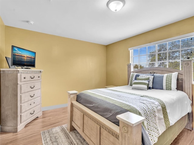 bedroom with baseboards and light wood-type flooring