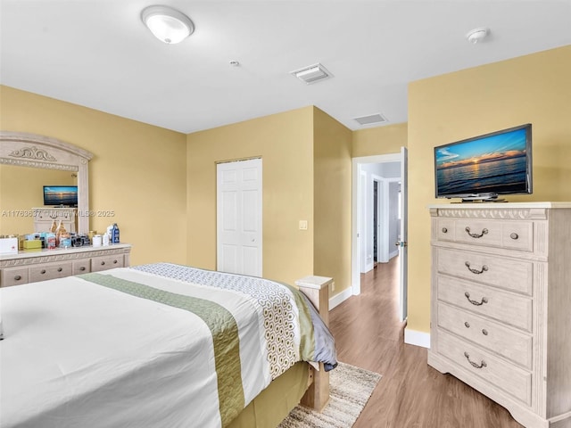 bedroom featuring wood finished floors, visible vents, and baseboards