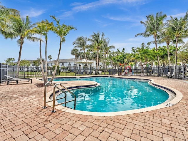 pool with a patio and fence