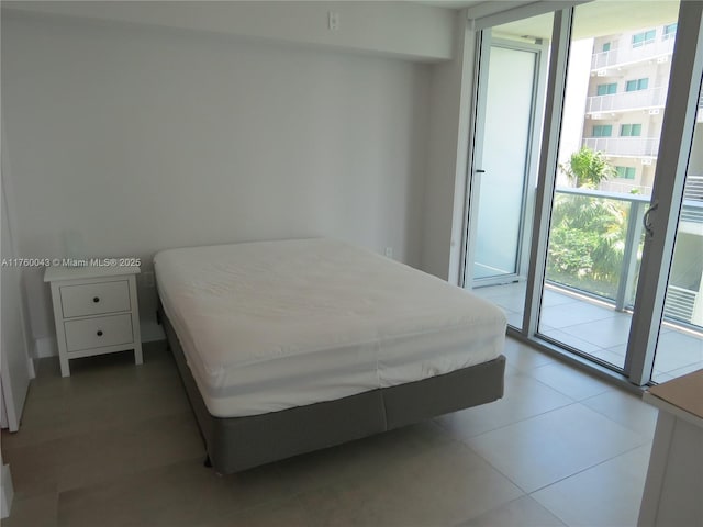 tiled bedroom featuring a wall of windows