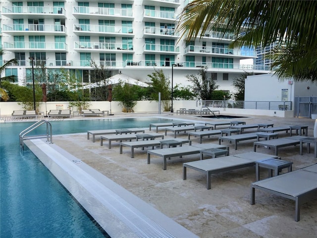 community pool with a patio and fence