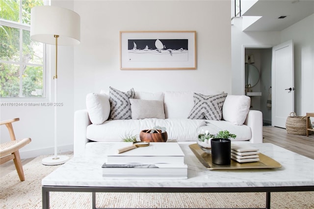 living room with visible vents, baseboards, and wood finished floors