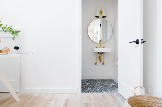 hallway featuring baseboards and wood finished floors