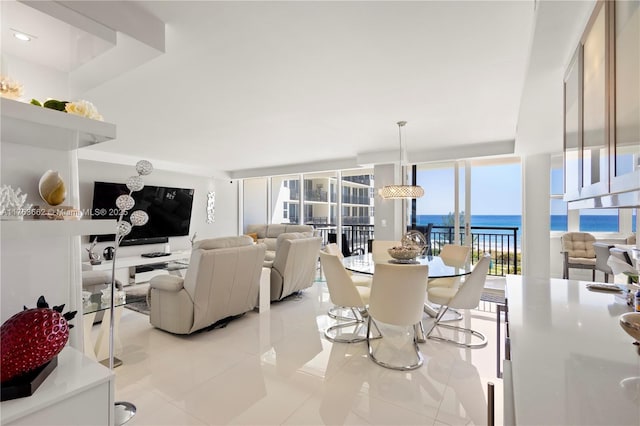 dining area with light tile patterned floors and a water view