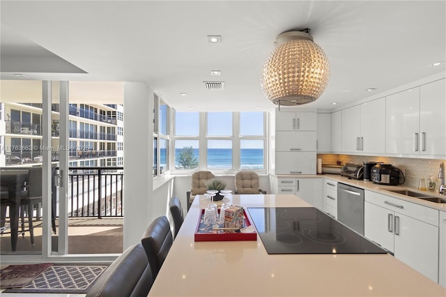 kitchen featuring a sink, white cabinetry, black electric cooktop, and stainless steel dishwasher