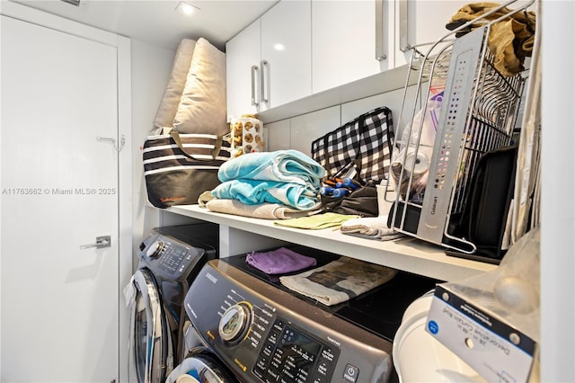 laundry room with cabinet space and washing machine and clothes dryer