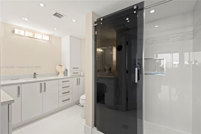 bathroom with vanity, a shower stall, visible vents, and tile patterned floors