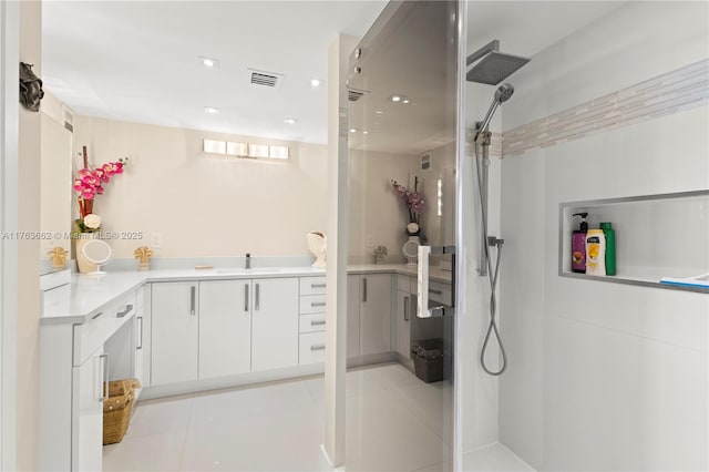 bathroom with tile patterned floors, visible vents, vanity, and walk in shower