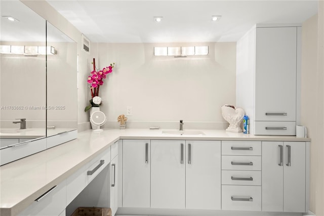 kitchen featuring a sink, white cabinetry, recessed lighting, and light countertops