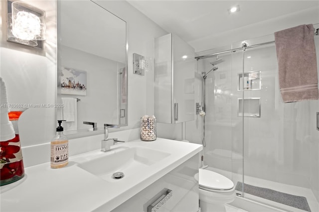 bathroom featuring a shower stall, toilet, and vanity