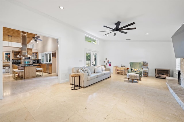 living room featuring a ceiling fan, baseboards, a fireplace, recessed lighting, and french doors