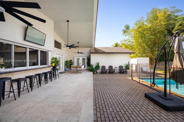 view of patio / terrace featuring a fenced in pool, french doors, fence, and outdoor dry bar