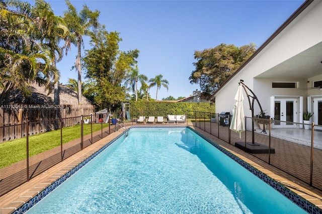 view of pool with a fenced in pool, french doors, a yard, a fenced backyard, and a patio