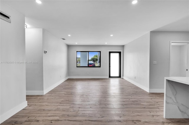 unfurnished living room featuring recessed lighting, visible vents, baseboards, and wood finished floors