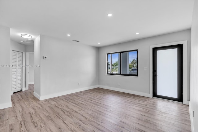 empty room with recessed lighting, wood finished floors, visible vents, and baseboards