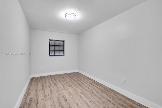 empty room with baseboards and wood finished floors