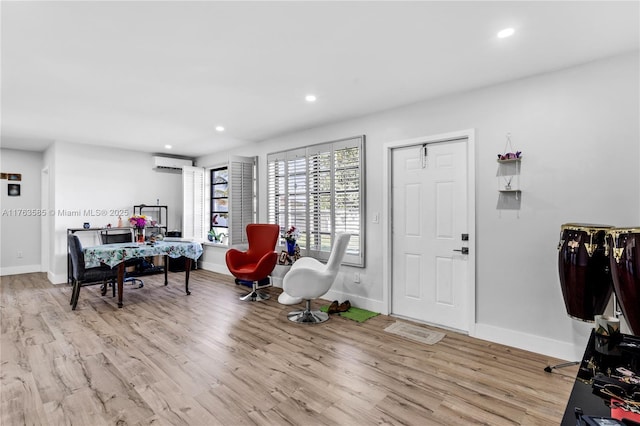 interior space featuring recessed lighting, baseboards, a wall unit AC, and wood finished floors