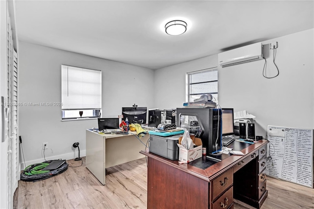 office area with an AC wall unit, light wood-style floors, and baseboards