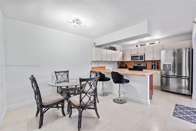 dining room featuring light tile patterned flooring and baseboards