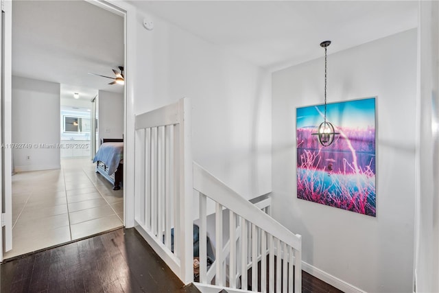 interior space with baseboards, wood finished floors, and a ceiling fan