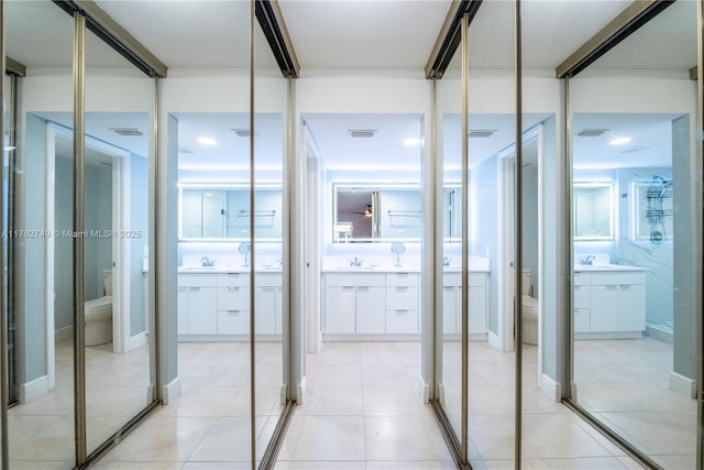 bathroom with vanity, toilet, and visible vents