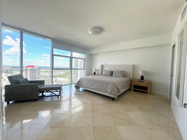 bedroom featuring a view of city, floor to ceiling windows, light tile patterned floors, and baseboards