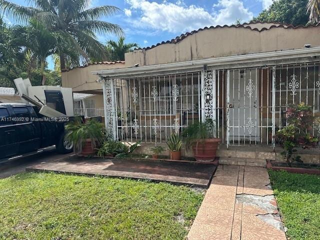 entrance to property with fence and stucco siding