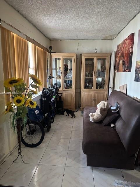 2162 NW 26th St, Miami, FL 33142 - living room with light tile patterned floors and a textured ceiling