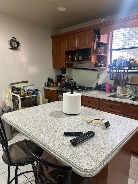 2162 NW 26th St, Miami, FL 33142 - kitchen featuring a sink, open shelves, gas range, and a center island