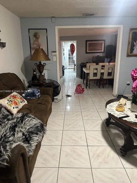 2162 NW 26th St, Miami, FL 33142 - living room with visible vents, a textured ceiling, and light tile patterned flooring