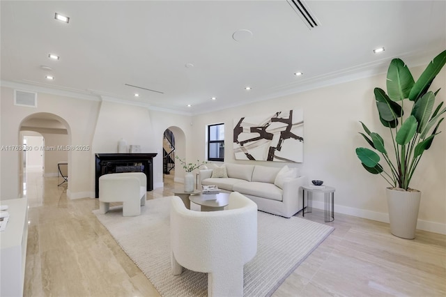 living area featuring crown molding, visible vents, and arched walkways