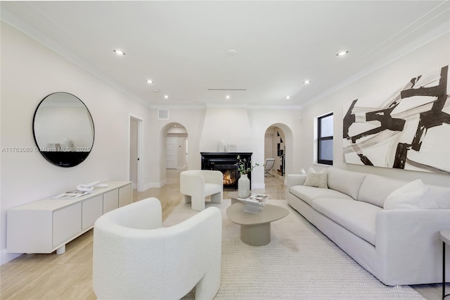 living room featuring recessed lighting, visible vents, arched walkways, and ornamental molding