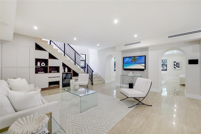 living area with arched walkways, recessed lighting, stairs, and baseboards