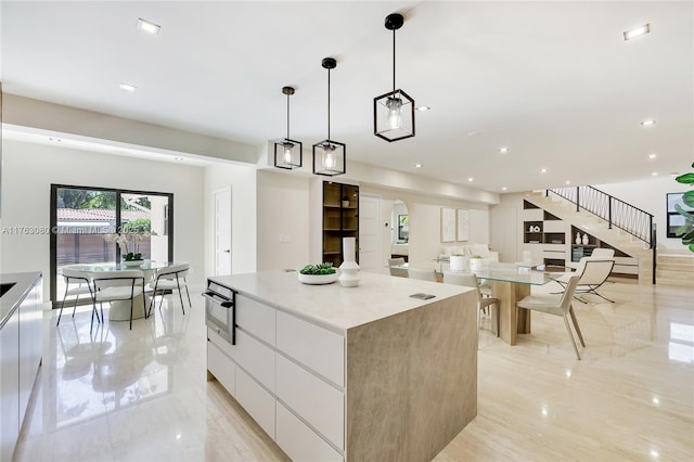 kitchen with marble finish floor, modern cabinets, a spacious island, recessed lighting, and white cabinets