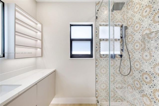 bathroom featuring tiled shower and vanity