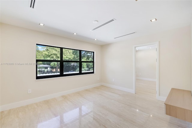 empty room with recessed lighting, visible vents, and baseboards