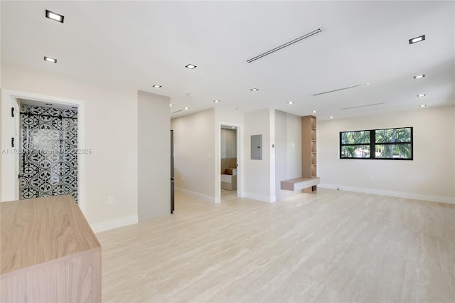 interior space with electric panel, light wood-type flooring, and recessed lighting